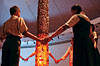 A group of children hold hands around the Harijan Pillar in the Eternal Gandhi Multimedia Museum