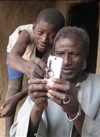 Alaburu Maiga, right, tries to use the camera on his cellphone with the help of an unidentified boy in the village of Gono, Mali, last year.